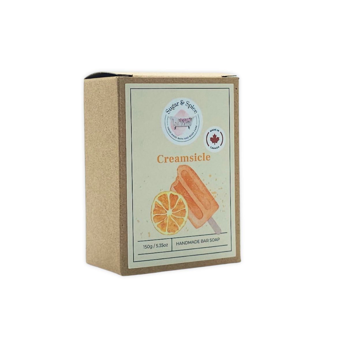 A packaged bar of Creamsicle handmade soap with the brand name Sugar & Spice visible on the label. The packaging is primarily beige with an illustration of an orange slice, indicating the scent or ingredient of orange in the soap.