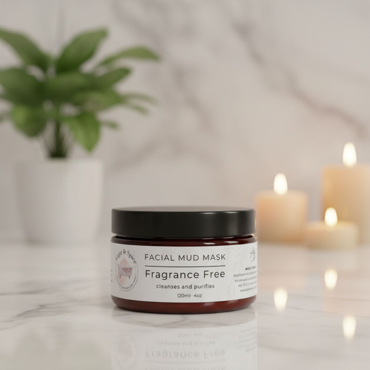 Facial mud mask jar on a marble surface with candles and a plant in the background