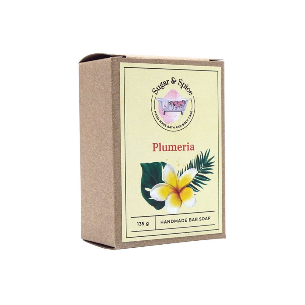 A packaged bar of Plumeria handmade soap with the brand name Sugar & Spice on the box, depicting an image of the soap and the plumeria flower.