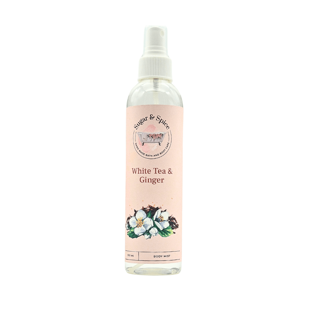 A bottle of White Tea & Ginger Body Mist with a white spray nozzle. The label shows the product name and an illustration of white tea leaves and ginger.