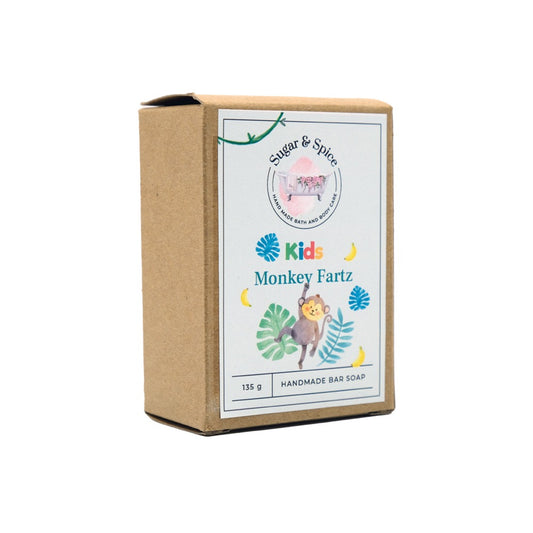 A packaged bar of Monkey Fartz soap with a label showing the product name and an illustration of a monkey. The package is marked 'Kids' and indicates the soap is handmade.