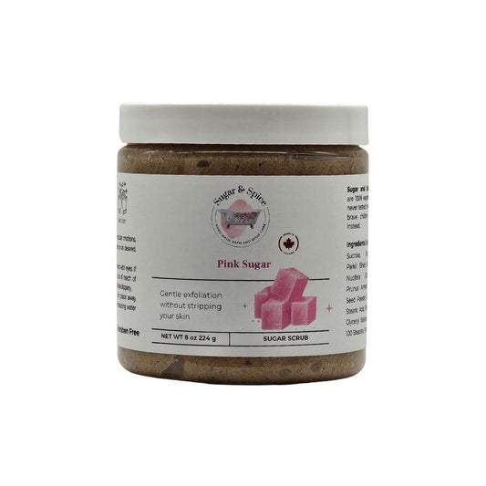 Jar of pink sugar scrub with a white label on a white background