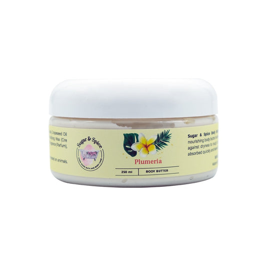 A jar of Plumeria Body Butter with a label showing the product name and a brief description. The jar is white with a beige label that has floral and leaf motifs.