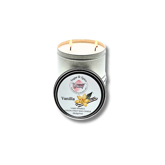 A silver tin container with a two-wick coconut wax candle, labeled 'Vanilla' on the lid.
