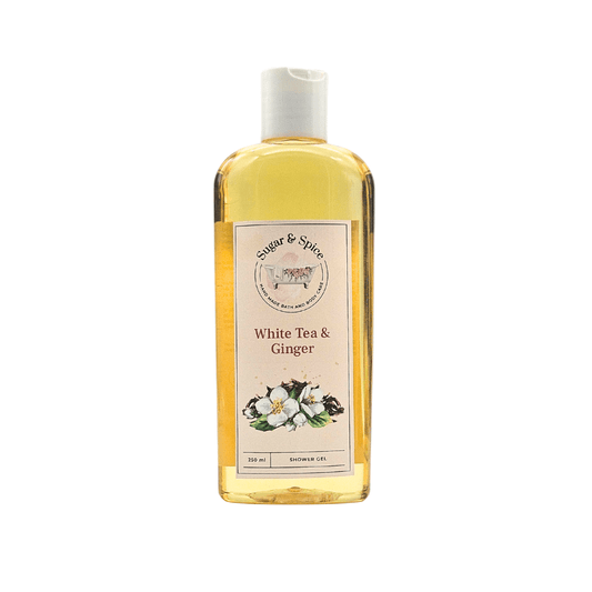 A clear plastic bottle containing yellow liquid labeled as White Tea & Ginger Shower Gel with an image of white tea and ginger on the label.