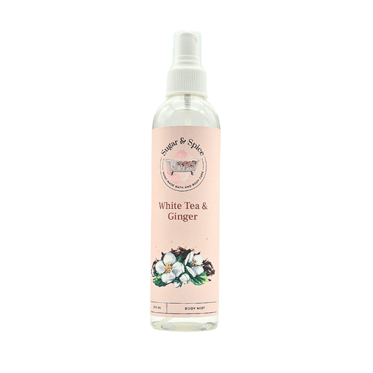 A bottle of White Tea & Ginger Body Mist with a white spray nozzle. The label shows the product name and an illustration of white tea leaves and ginger.