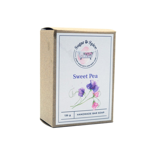 A packaged bar of Sweet Pea handmade soap with the brand name, product name, and weight (115 g) displayed on the label.